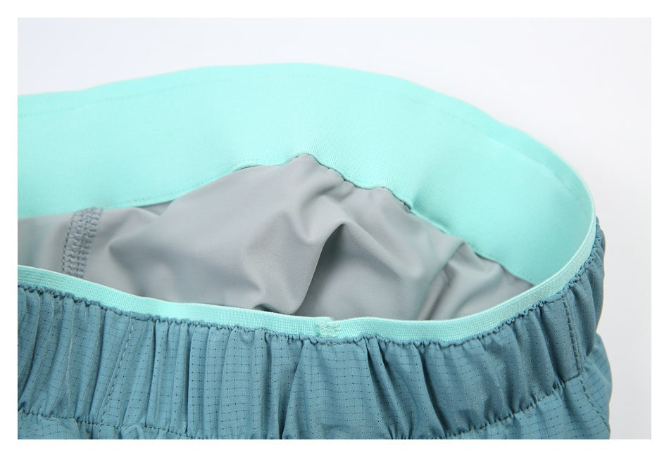 Interior close-up of blue shorts showing the bright aqua waistband and gray lining.