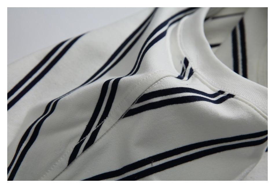 Close-up of a cream garment with navy stripes, showing the neckline and stitching.