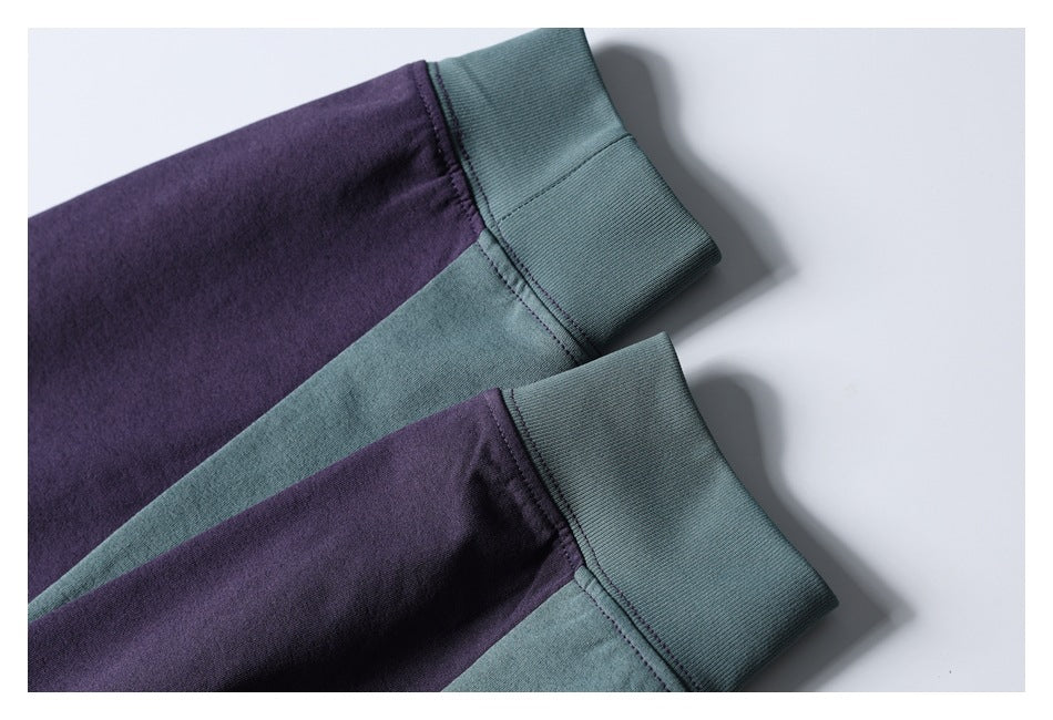 Close-up of two ribbed teal cuffs attached to purple and teal garment sections.