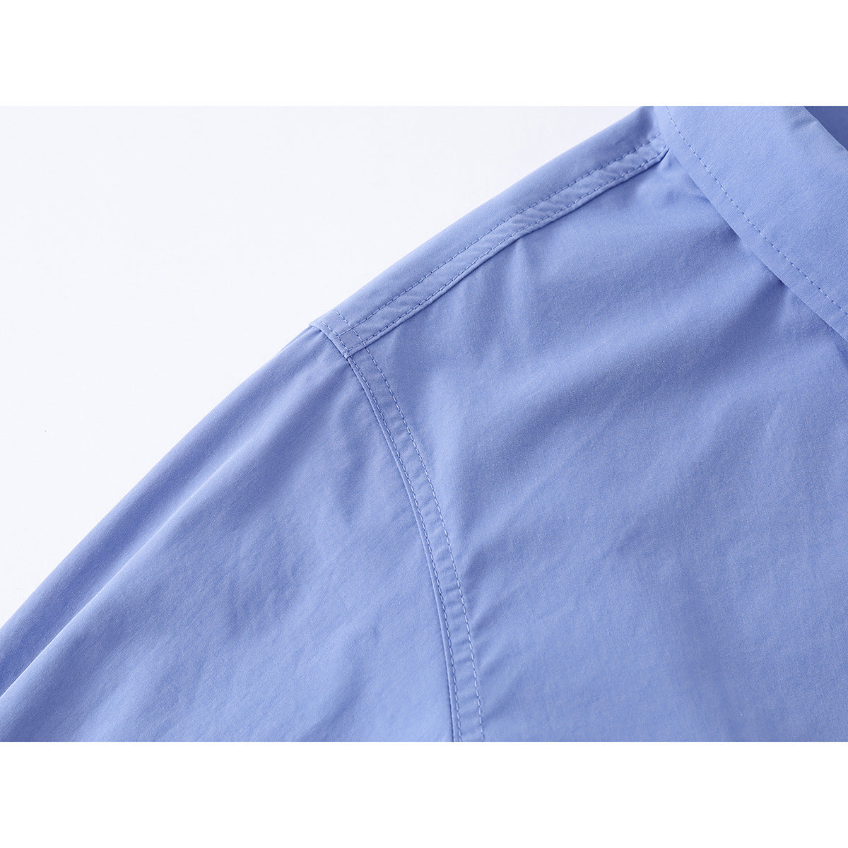 Close-up of the light blue shirt's shoulder seam and upper sleeve.