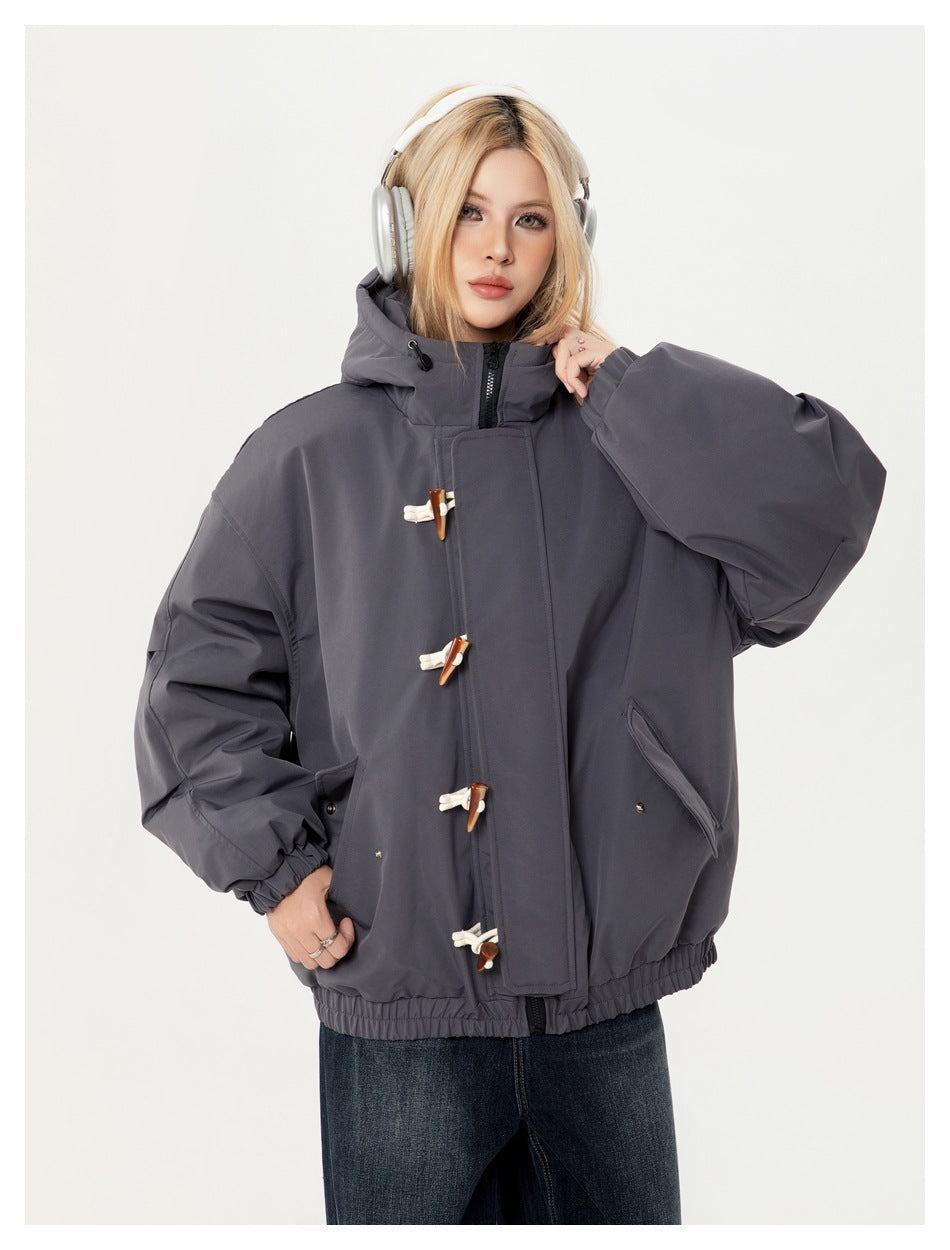 Close view of a model wearing a charcoal gray hooded jacket with toggle closures and angled pockets.