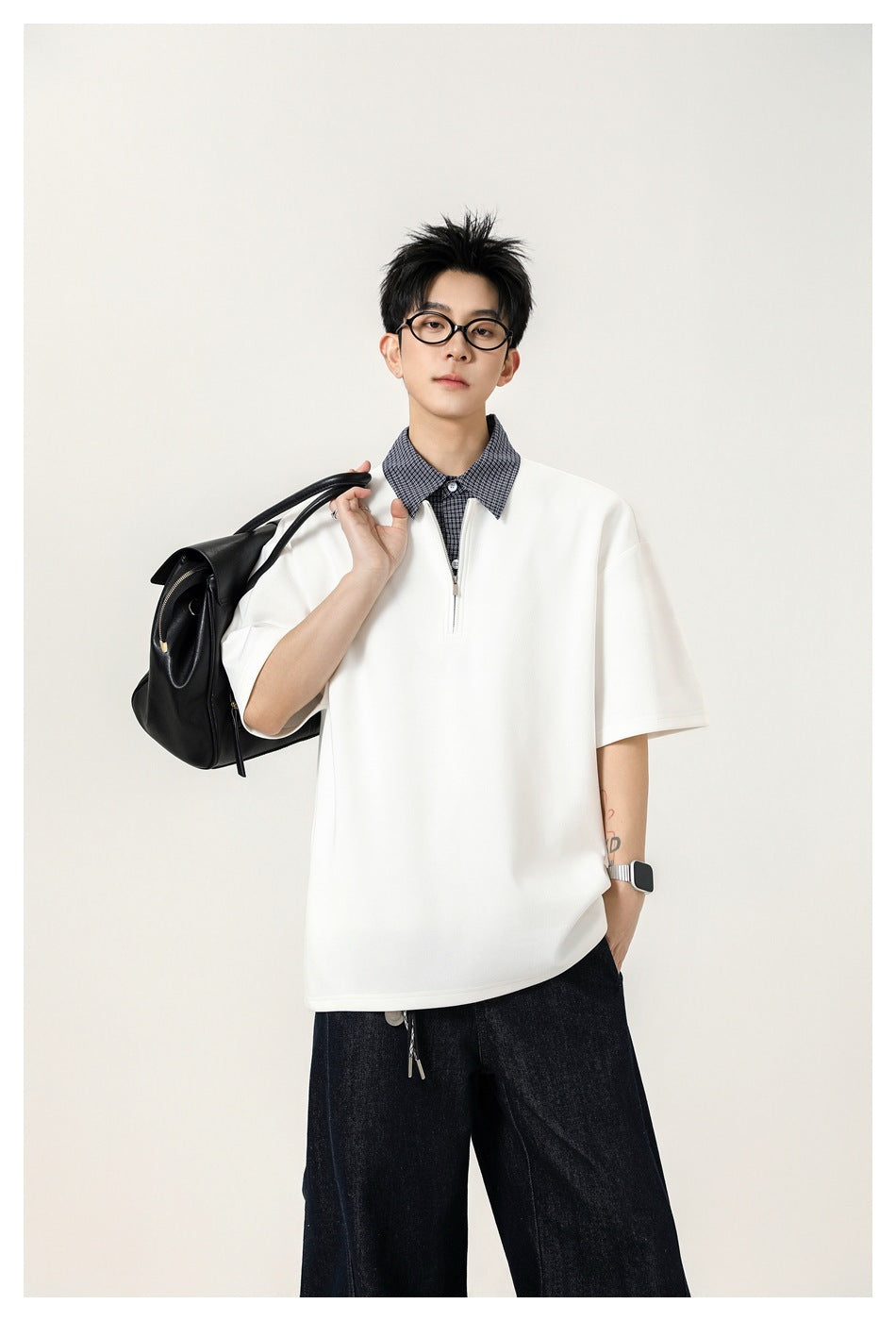 Model in white half-zip short-sleeve top with check shirt collar, black bag over shoulder, waist-up view