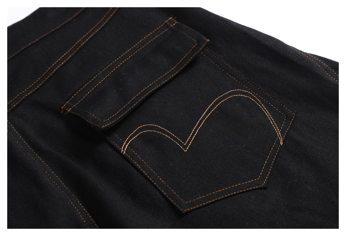 Close-up of a black denim back pocket with a curved double-stitched design in brown thread.