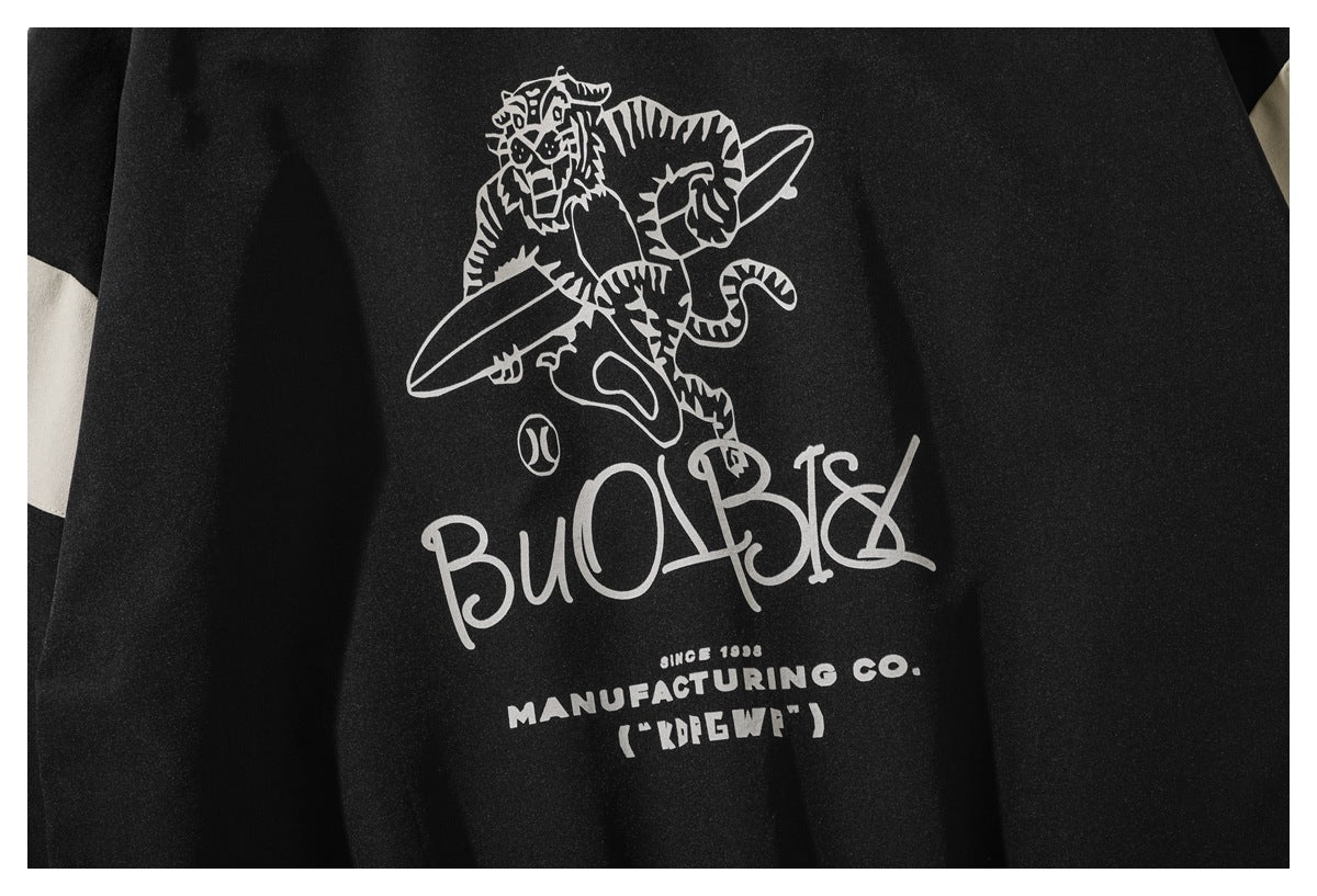 Close-up of a white tiger graphic and stylized lettering printed on black jacket fabric.