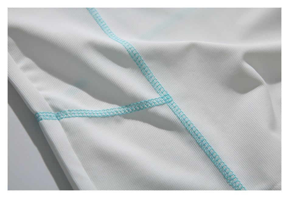 Close-up of intersecting turquoise seams on white textured fabric.