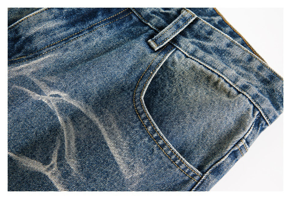 Close-up of a front pocket, belt loop, and pale faded pattern on blue jeans.