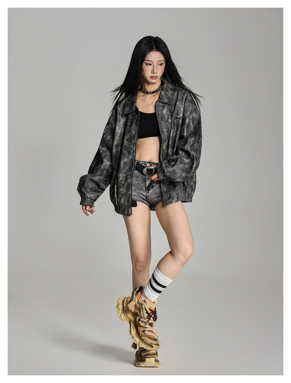 Full-length model wearing an open charcoal-gray textured jacket over a black crop top and shorts.