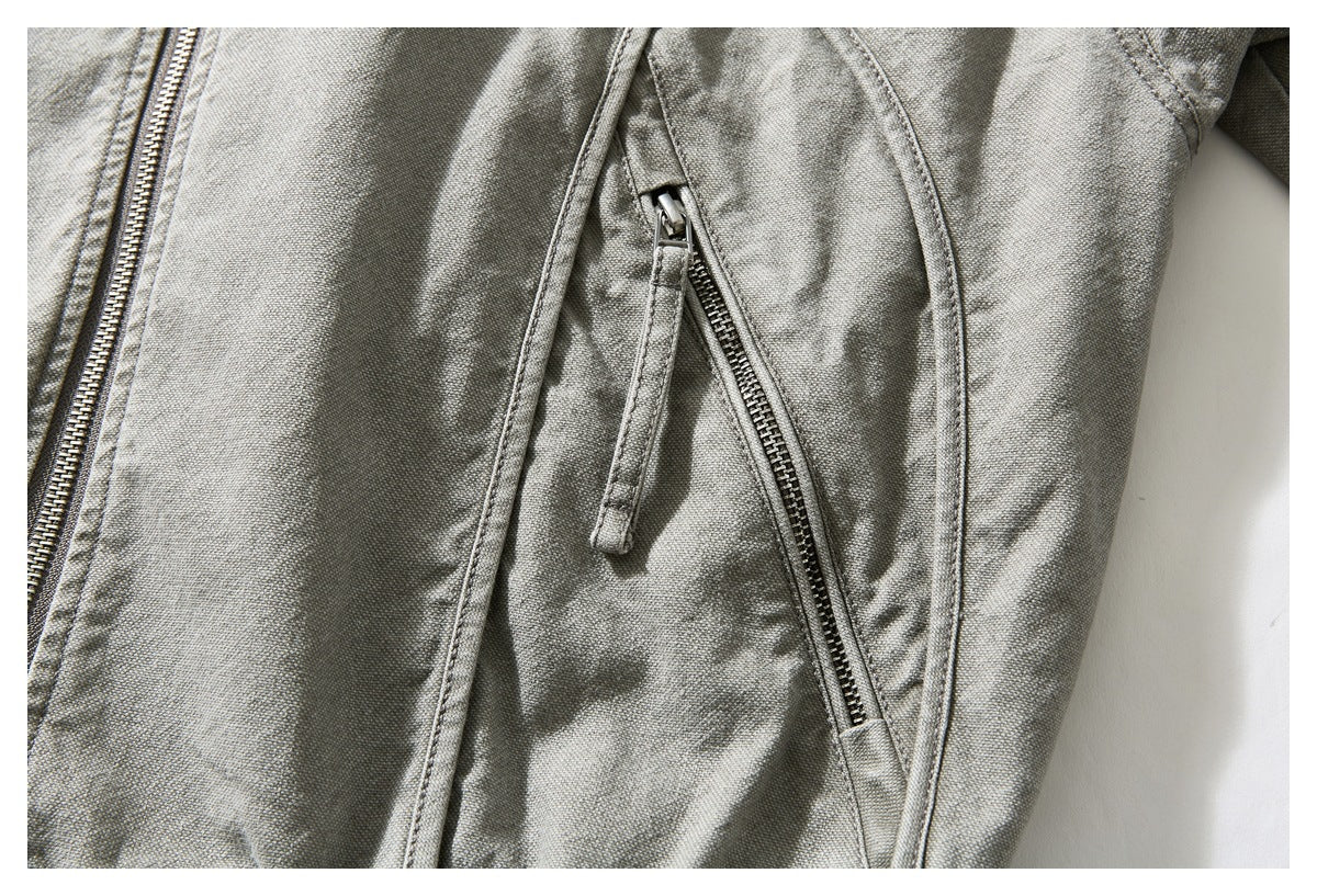 Close-up of a gray-green jacket's angled zippered pocket beside the main zipper.