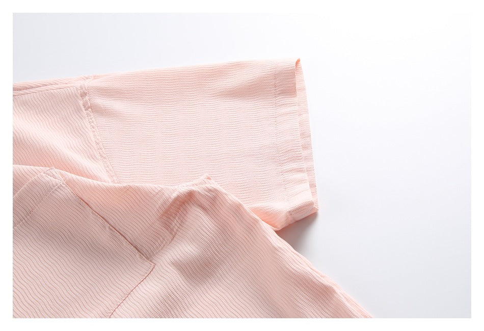 Close-up of the pale pink shirt sleeve and stitched seams.