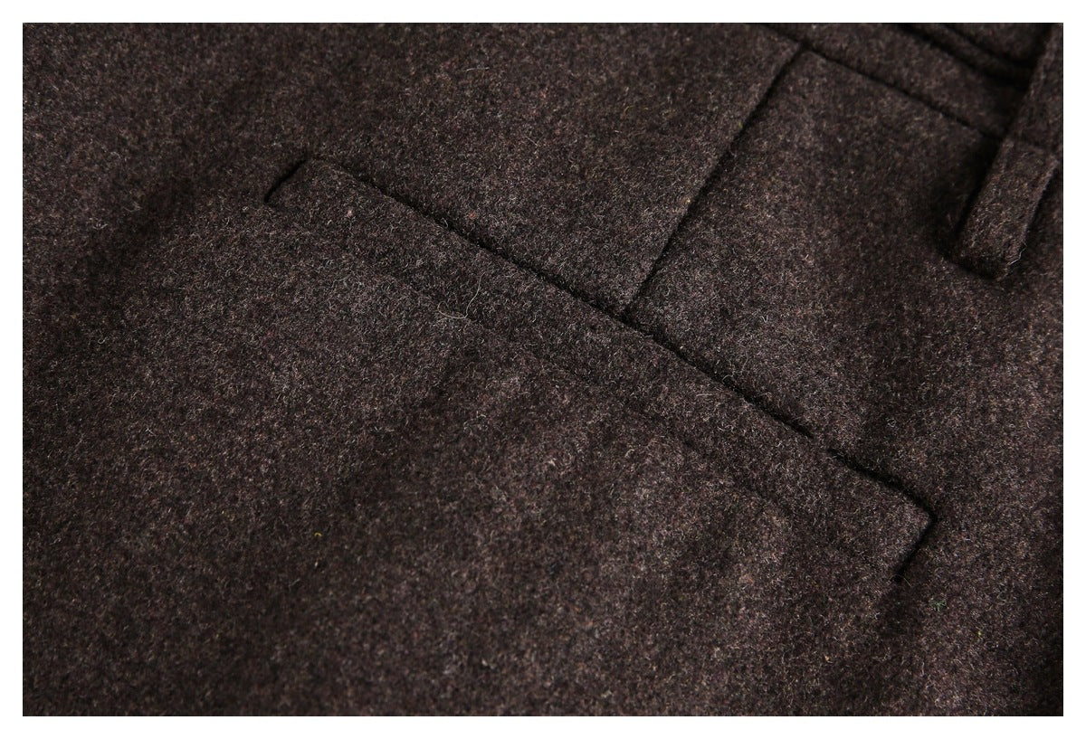 Close-up of a welt pocket and belt loop on dark brown trousers.