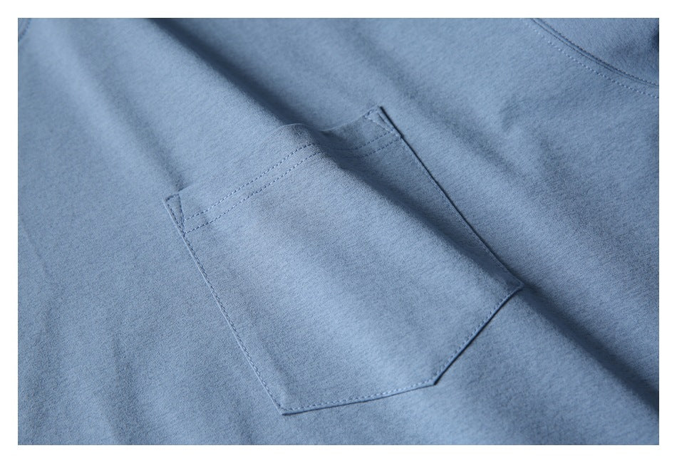 Close-up of a blue garment's stitched patch pocket and seams.