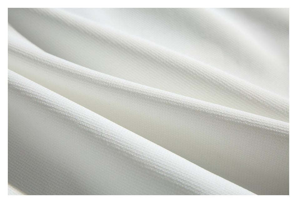 Extreme close-up showing the textured surface of white garment fabric.