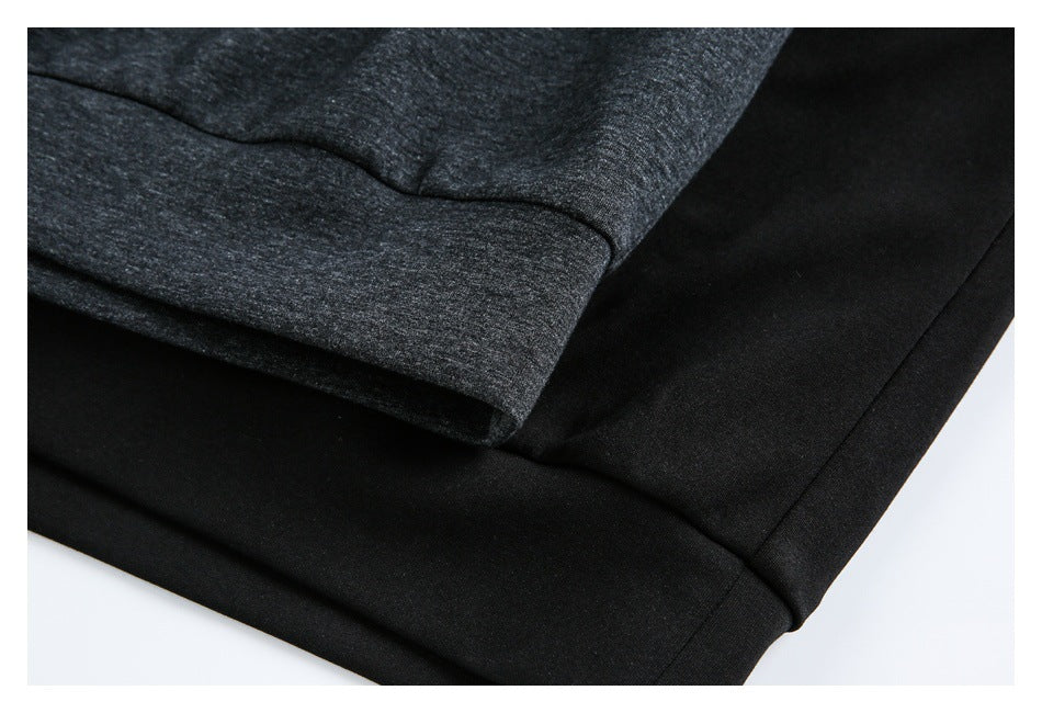 Close-up of the dark pullover's hem and ribbed cuff fabric in charcoal and black.