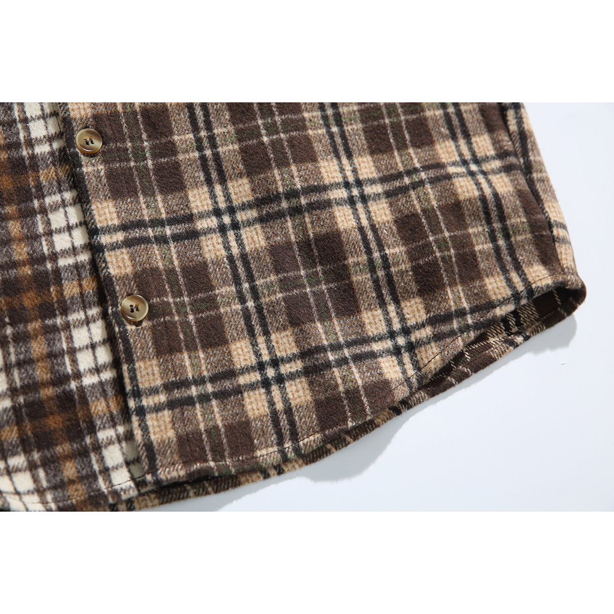 Close-up of the brown and cream plaid shirt's lower hem and front buttons.