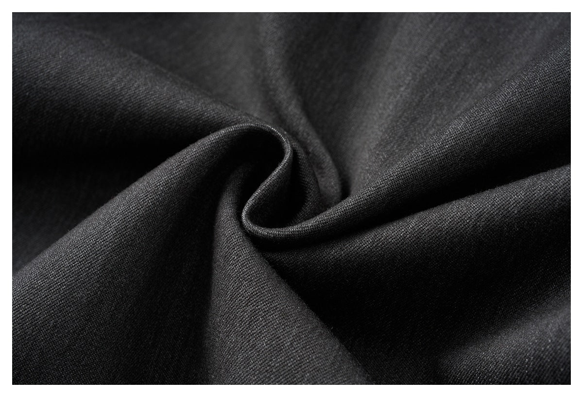 Close-up of black fabric gathered into a curled fold, revealing a fine, even texture.
