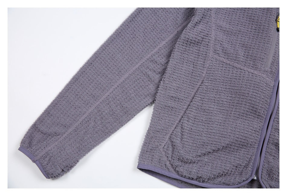 Close-up of the jacket sleeve and front, showing textured fabric, seam details, and bound edges.