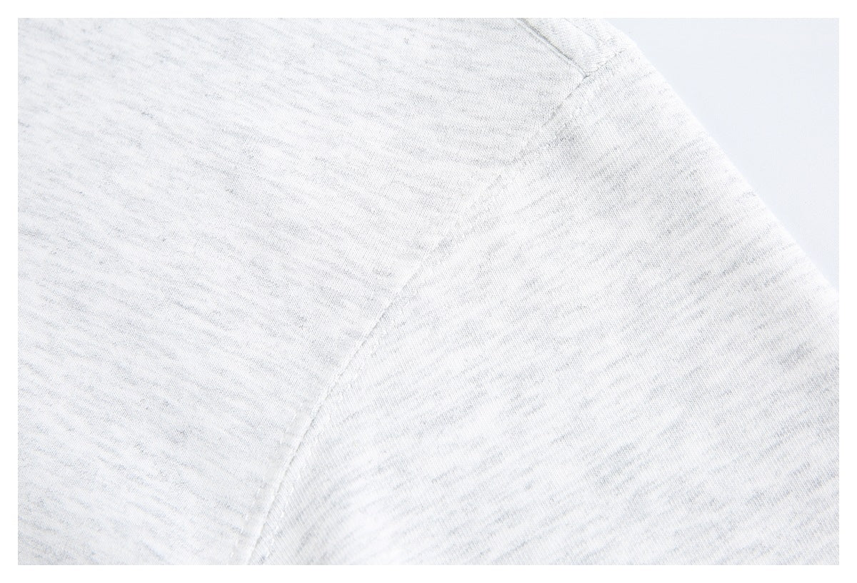 Close-up of the light gray heather T-shirt’s shoulder seam and fabric texture.