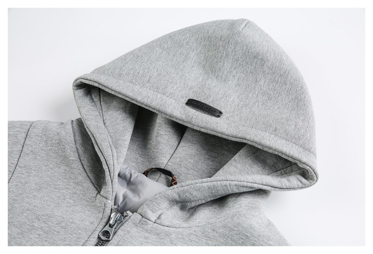 Close-up of the gray sweatshirt’s hood, showing its black tab, lining, and top of the zipper.