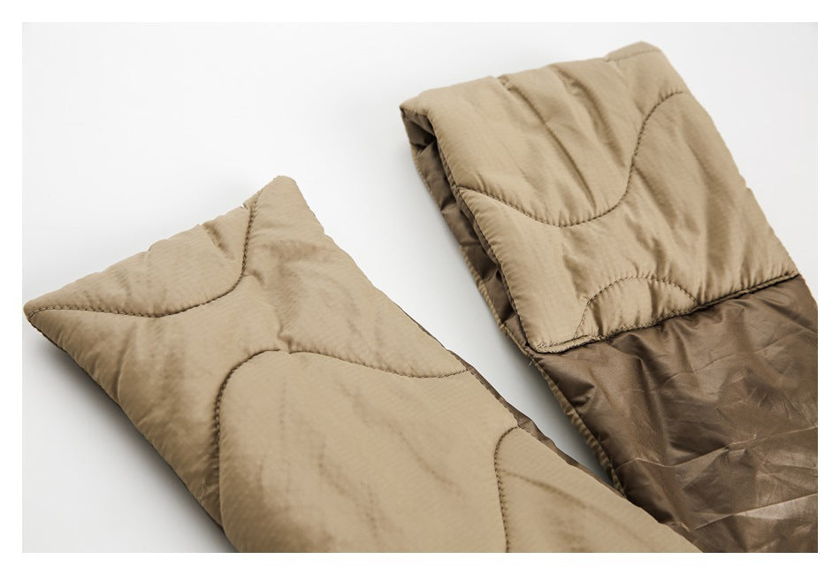 Close-up of tan padded outerwear with curved quilt stitching and a dark brown lining.