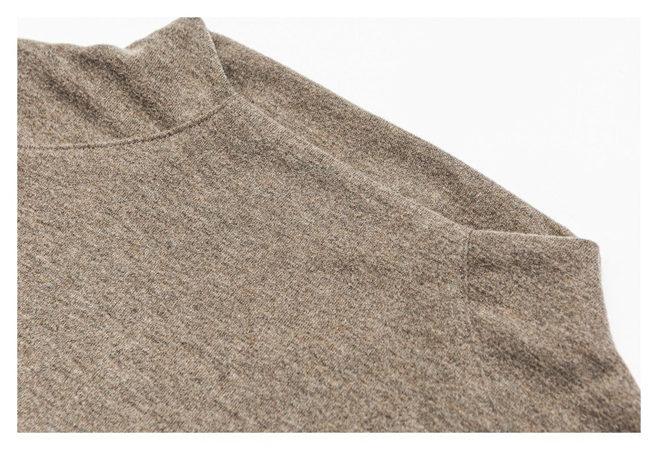 Close-up of a taupe heathered top's high neckline, shoulder seam, and sleeve.