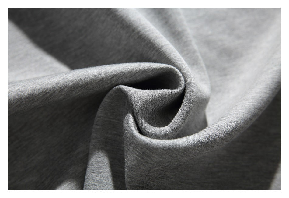 Close-up of softly folded gray fabric showing its fine heathered texture.