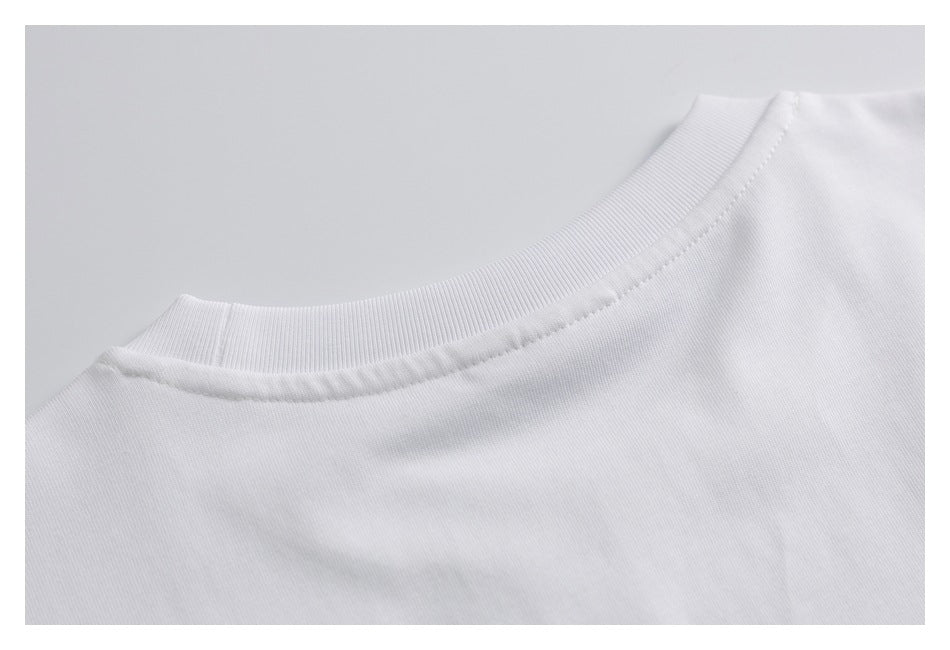 Close-up of a white shirt’s ribbed crew neckline and shoulder seam.