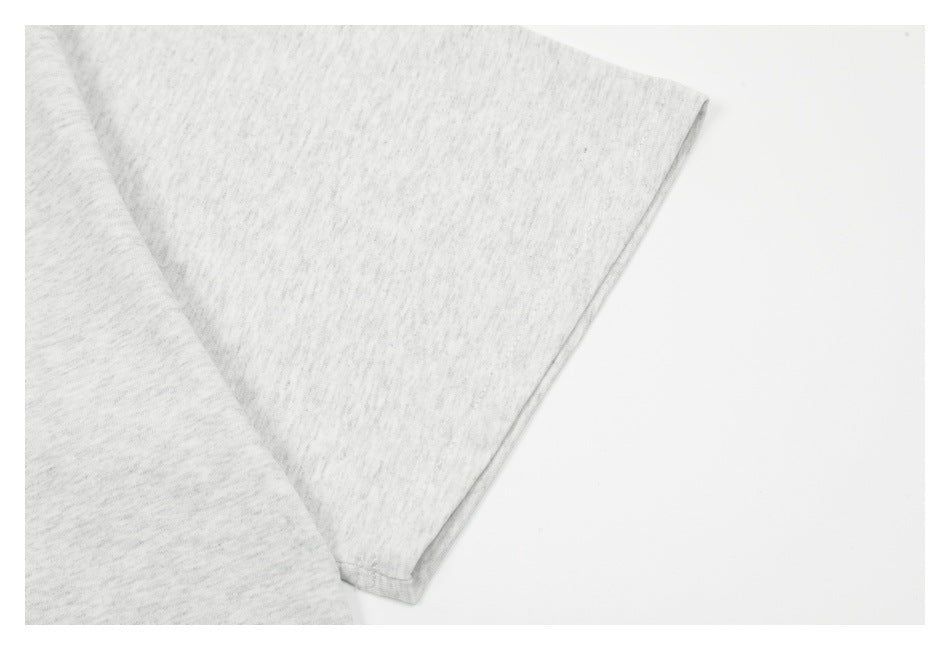 Close-up of a light heather gray garment sleeve and stitched edge on a white background.