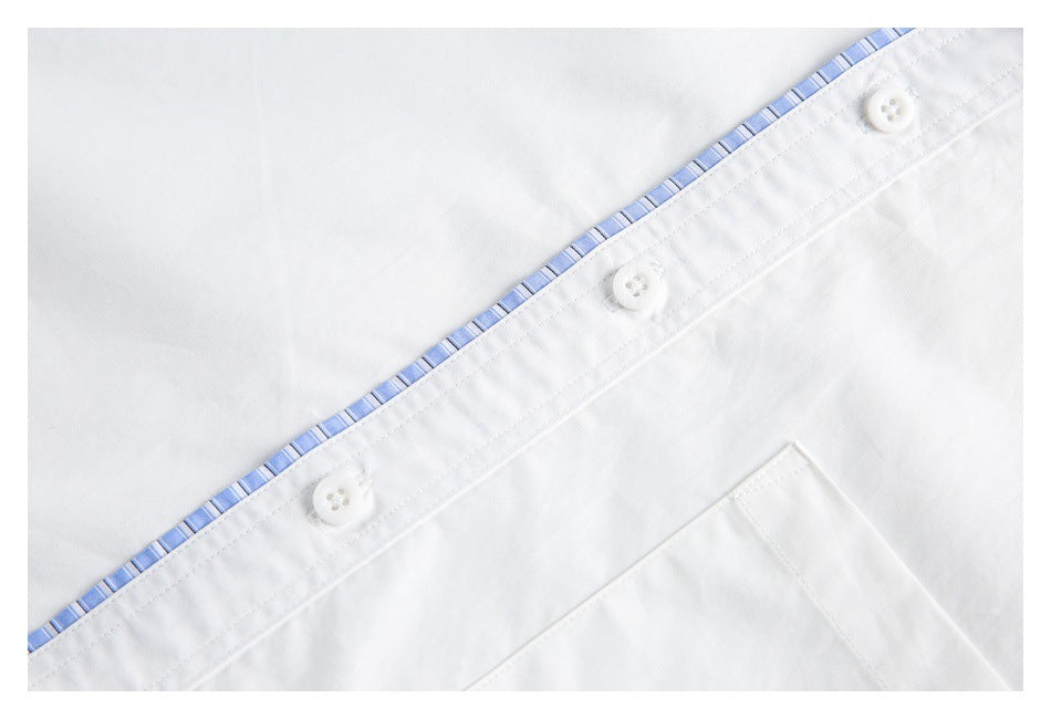 Close-up of the white shirt's button placket with blue striped edge trim and part of the chest pocket.