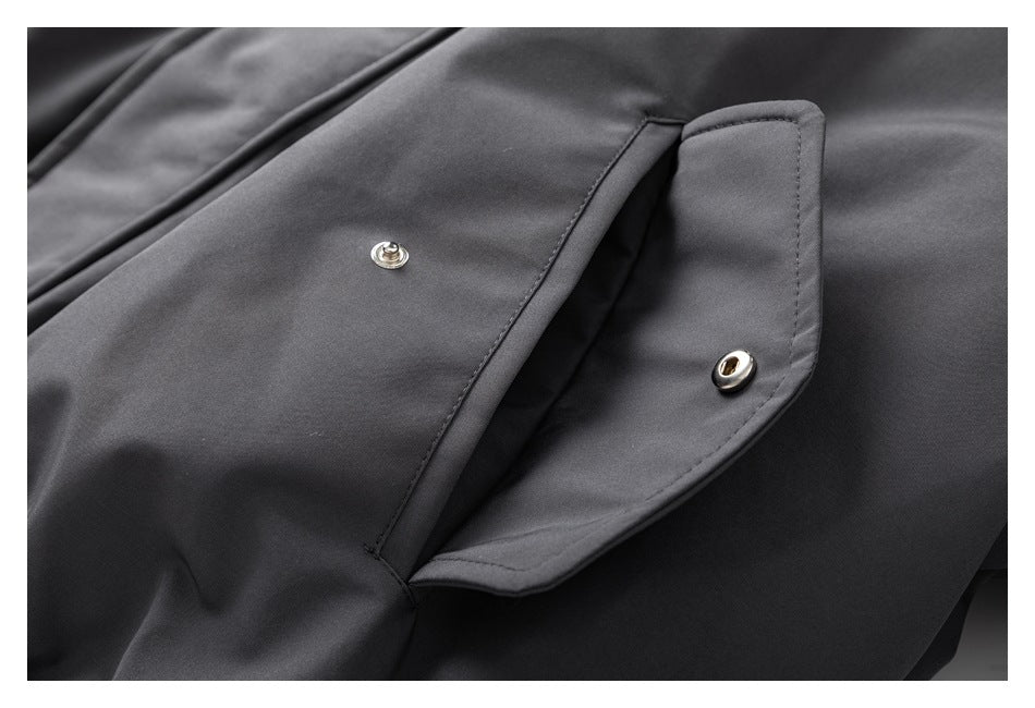 Close-up of a snap-button pocket flap on a dark gray jacket.