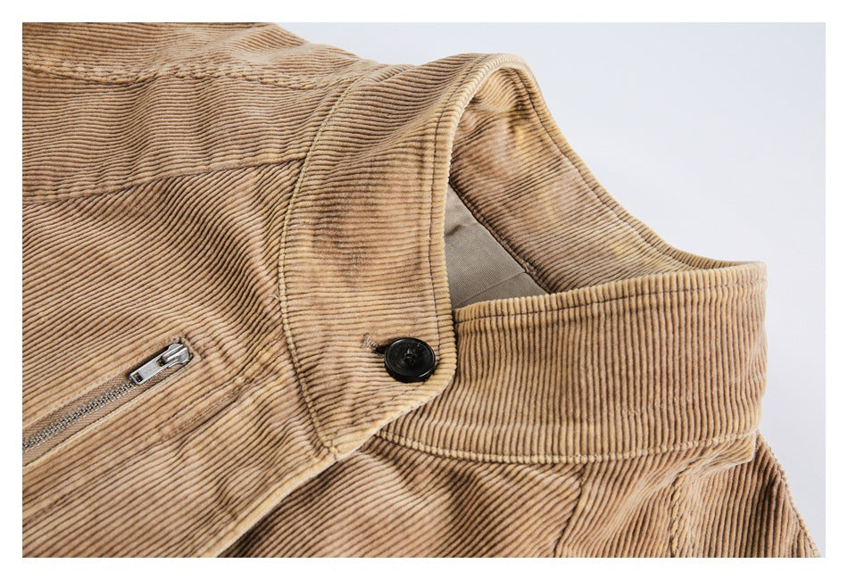 Tan corduroy jacket collar with a black button and part of a metal zip pocket.