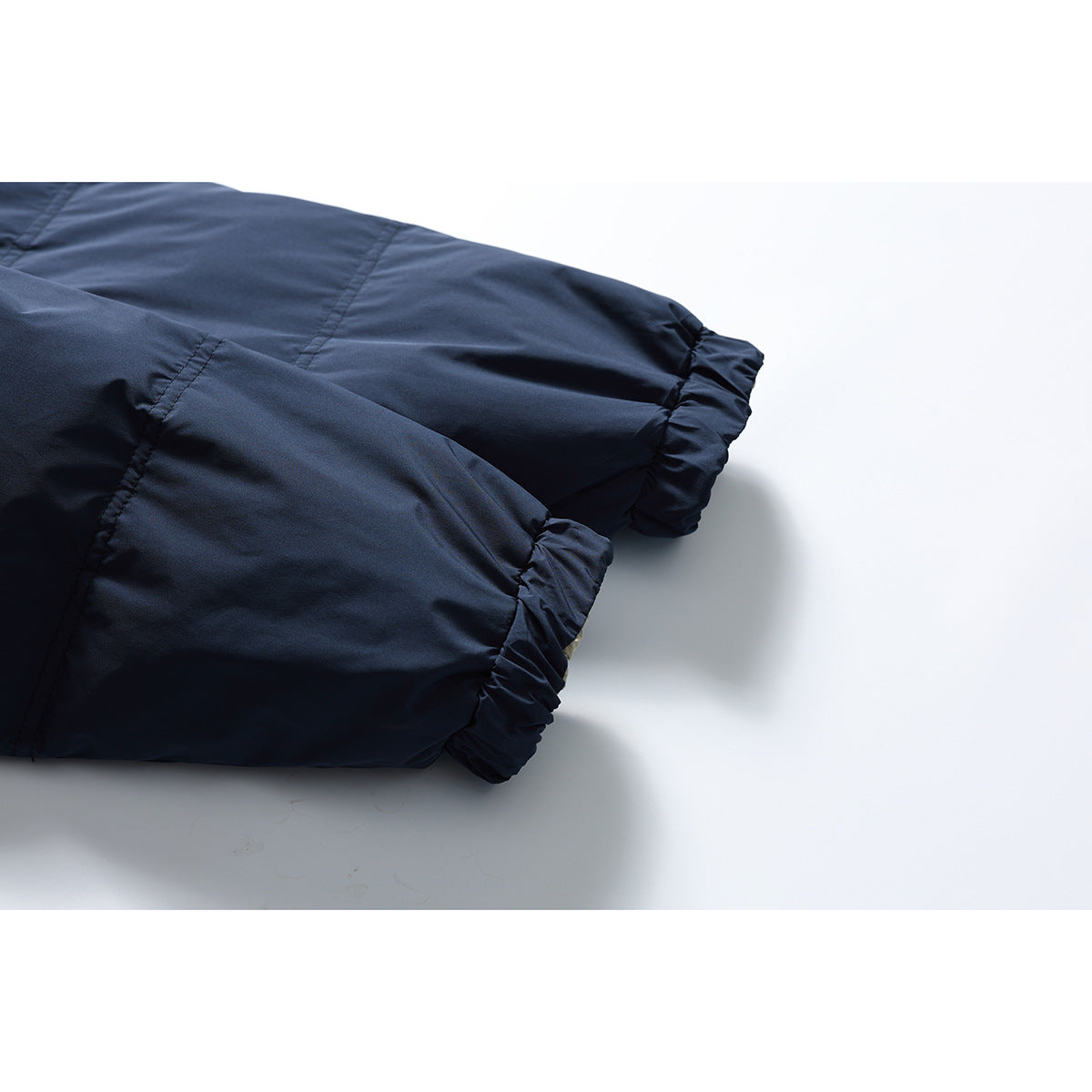 Close-up of the navy jacket's sleeves and gathered elastic cuffs.