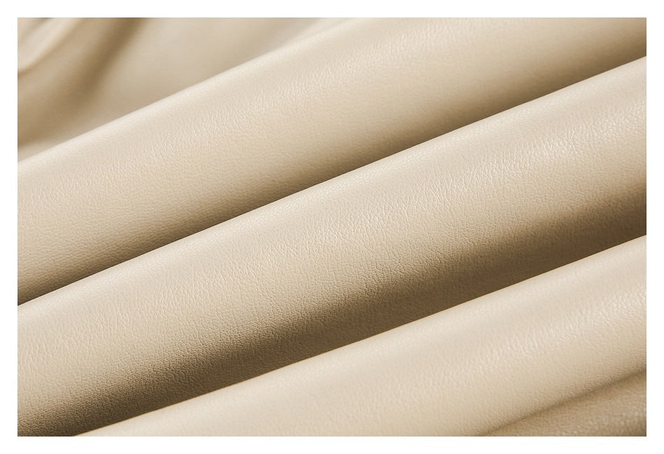Extreme close-up of the beige garment's fine pebbled surface and soft folds.