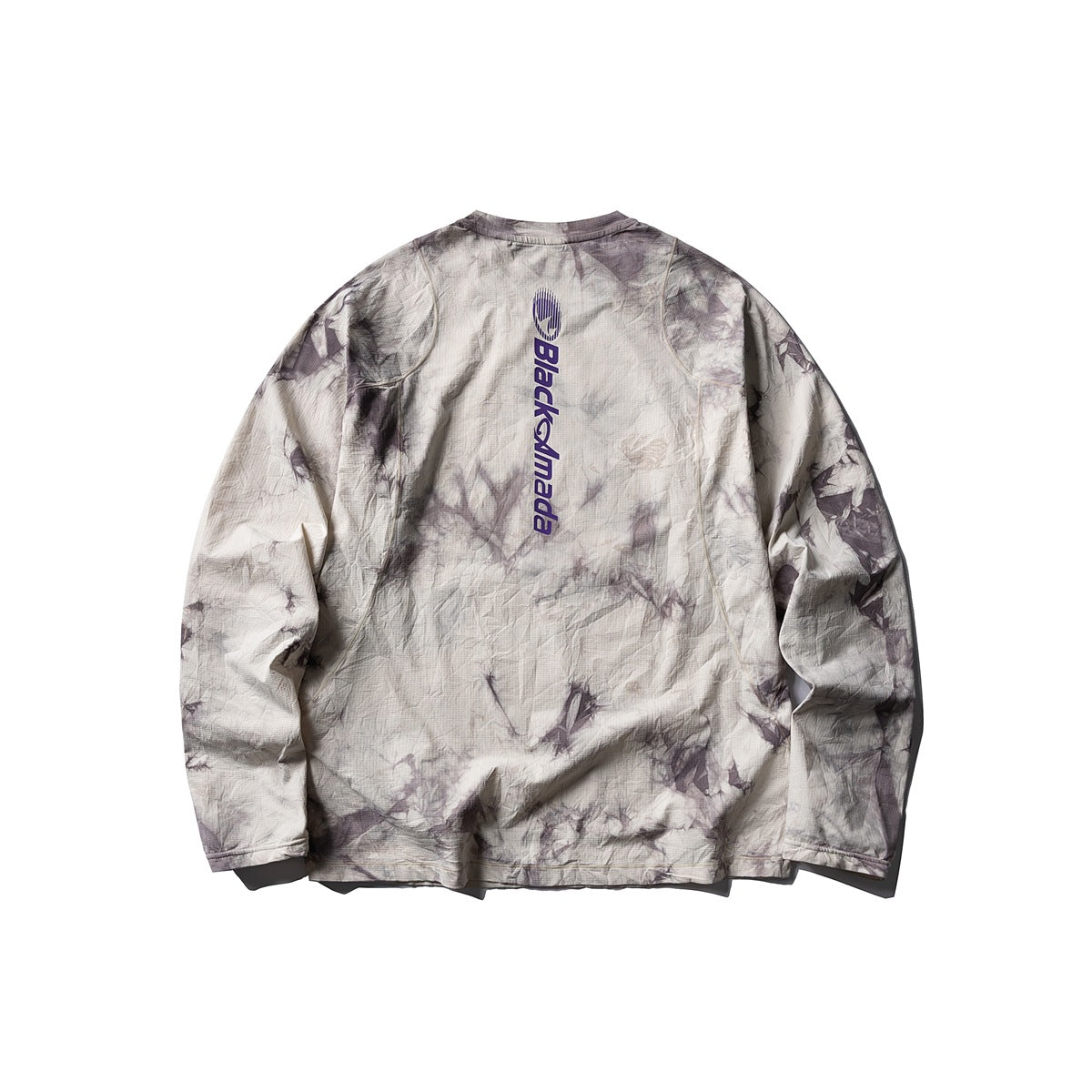 Back view of a cream and gray-purple tie-dye long-sleeve shirt with vertical navy lettering printed on the upper back.