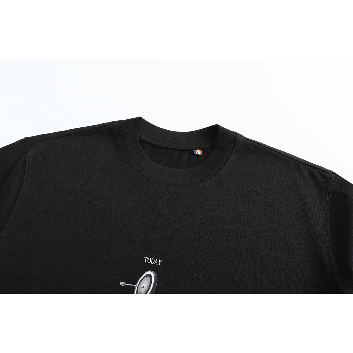 Close-up of a black crew-neck T-shirt with a small white “TODAY” label above a target illustration.