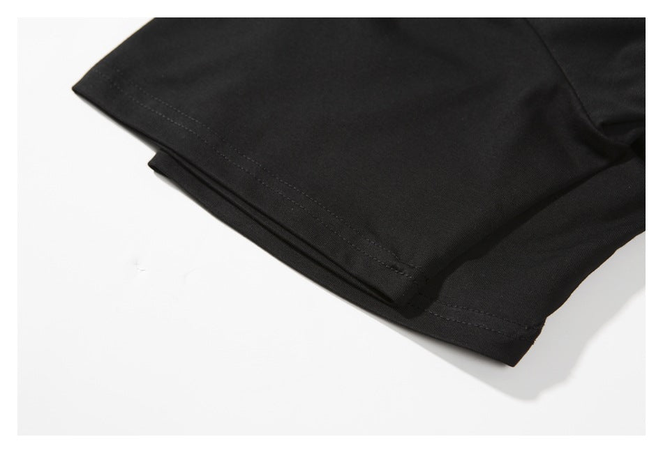 Close-up of a black T-shirt sleeve with a double-stitched hem on a light background.