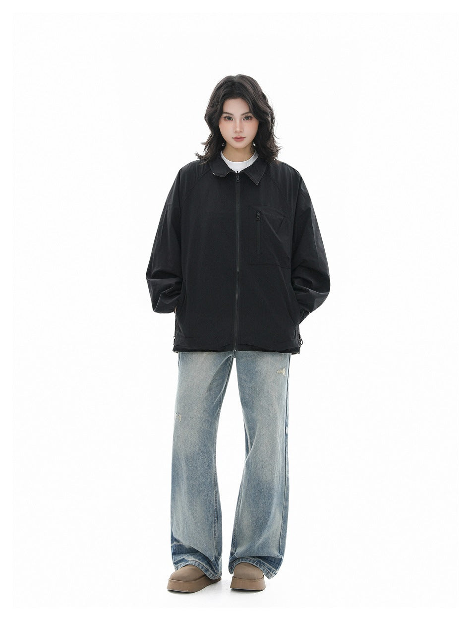 Model wearing a black zip-front jacket over a white top with light-wash wide-leg jeans and tan platform shoes