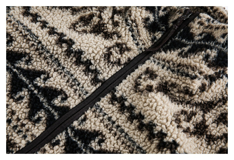 Close-up of a black zipper running diagonally across plush beige, brown, and black patterned fleece.