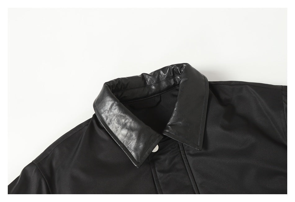 Close-up of a black jacket's shiny black collar and upper front with a silver snap.