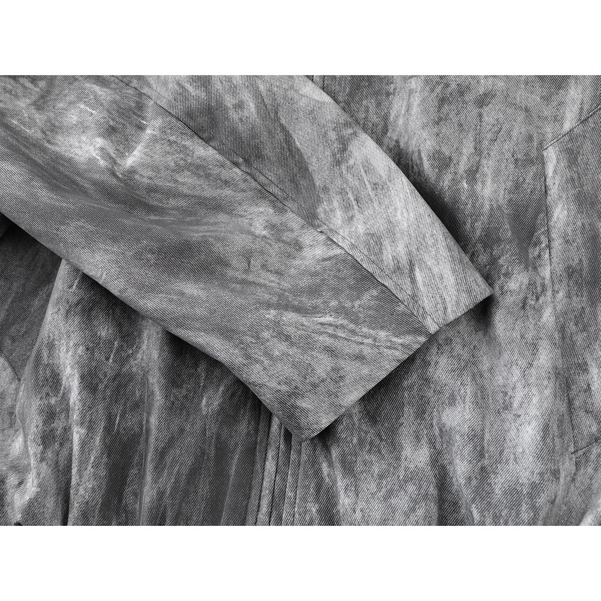 Close-up of the sleeve and cuff of a gray mottled jacket.