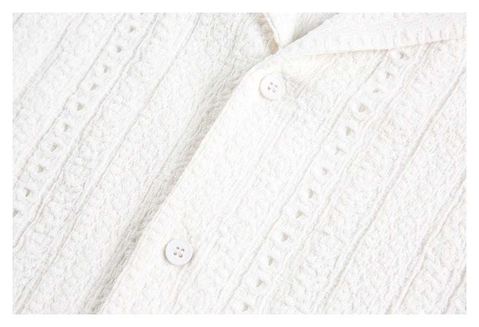 Close-up of a white shirt placket with buttons and decorative openwork fabric stripes.