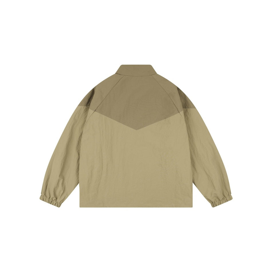 Back view of a tan jacket with a darker brown chevron-shaped shoulder panel and elastic cuffs.