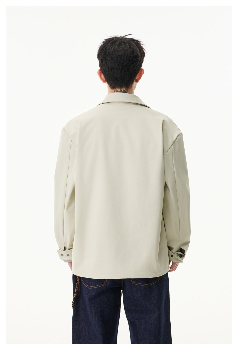 Back view of a model wearing an ivory jacket with a pointed collar, long sleeves and buttoned cuffs.