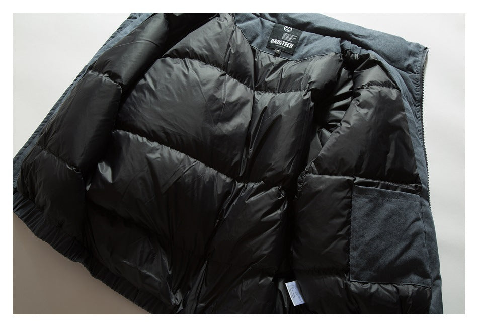 Close-up of an opened dark jacket showing black quilted lining, a zipper, pocket, and interior neck label.