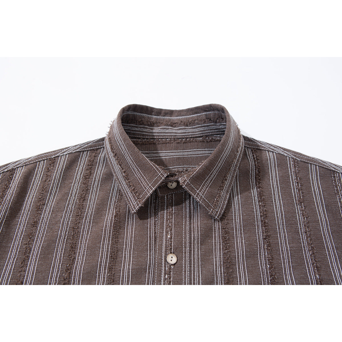 Close-up of a brown striped shirt collar, placket, and light buttons.