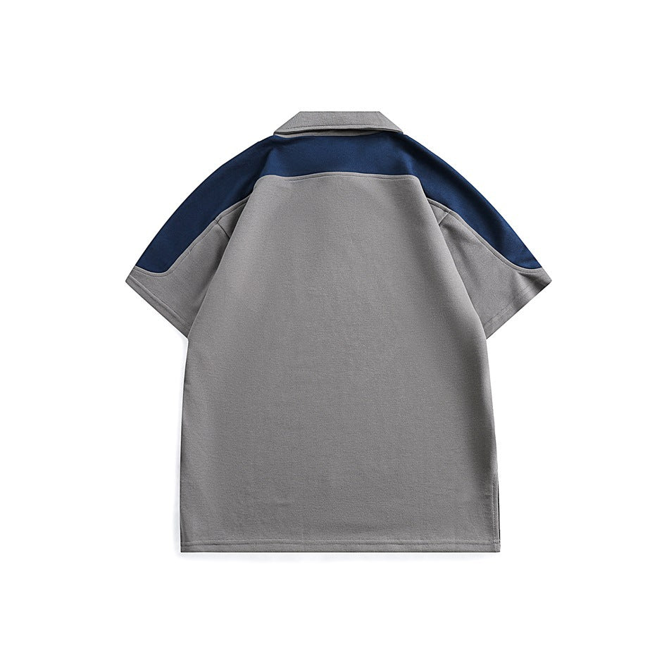 Back view of gray short-sleeve polo shirt with navy yoke and navy shoulder and sleeve panels, flat lay
