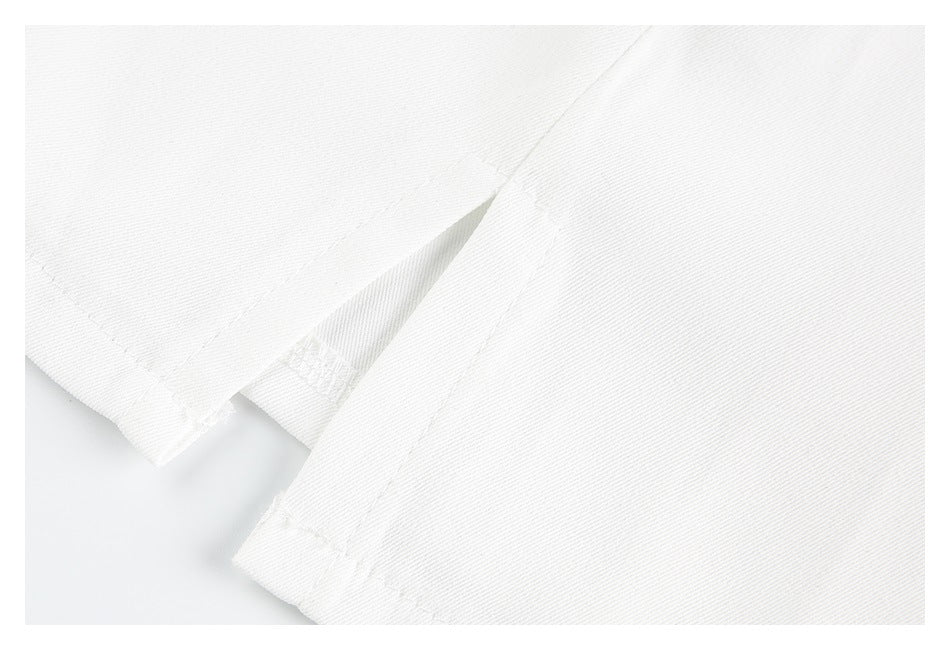 Close-up of white garment fabric with overlapping stitched edges and a finished seam.