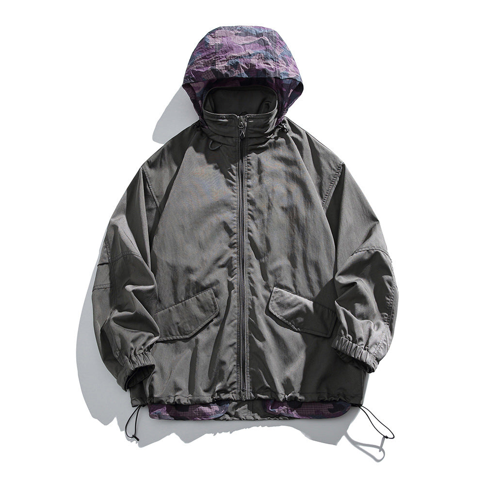 Dark gray hooded zip jacket with purple camouflage hood lining, flap pockets and drawcord hem, flat lay