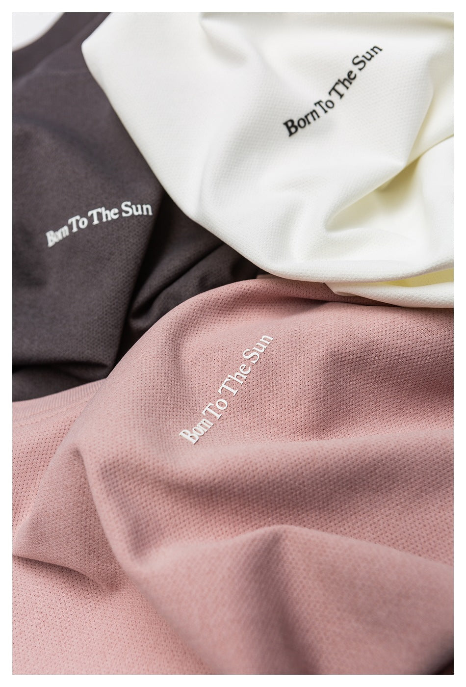 Close-up of white, charcoal, and dusty pink perforated fabric with “Born To The Sun” lettering.