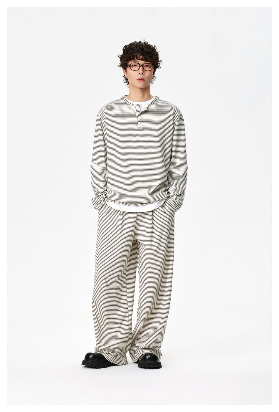 Front view of a model in an ivory thin-striped henley and matching wide-leg pants.