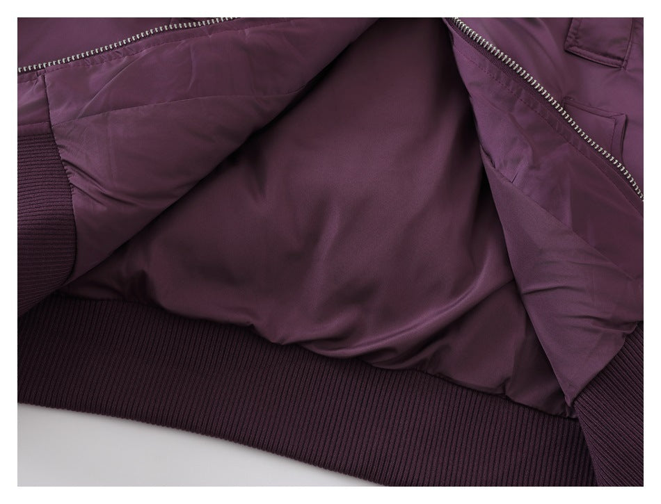 The plum-purple jacket is opened to show its smooth inner lining, zipper edges, and ribbed hem.